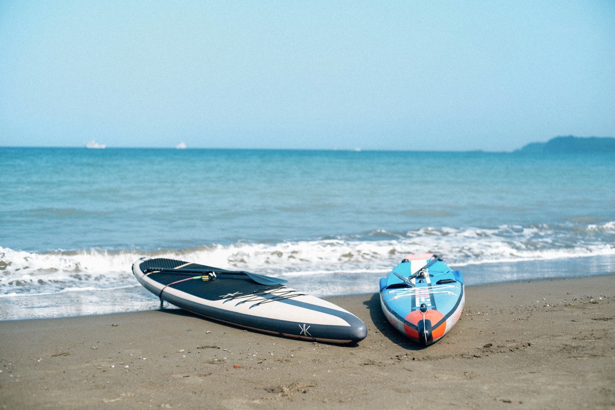 浜辺に並ぶ2枚のSUPボードと海