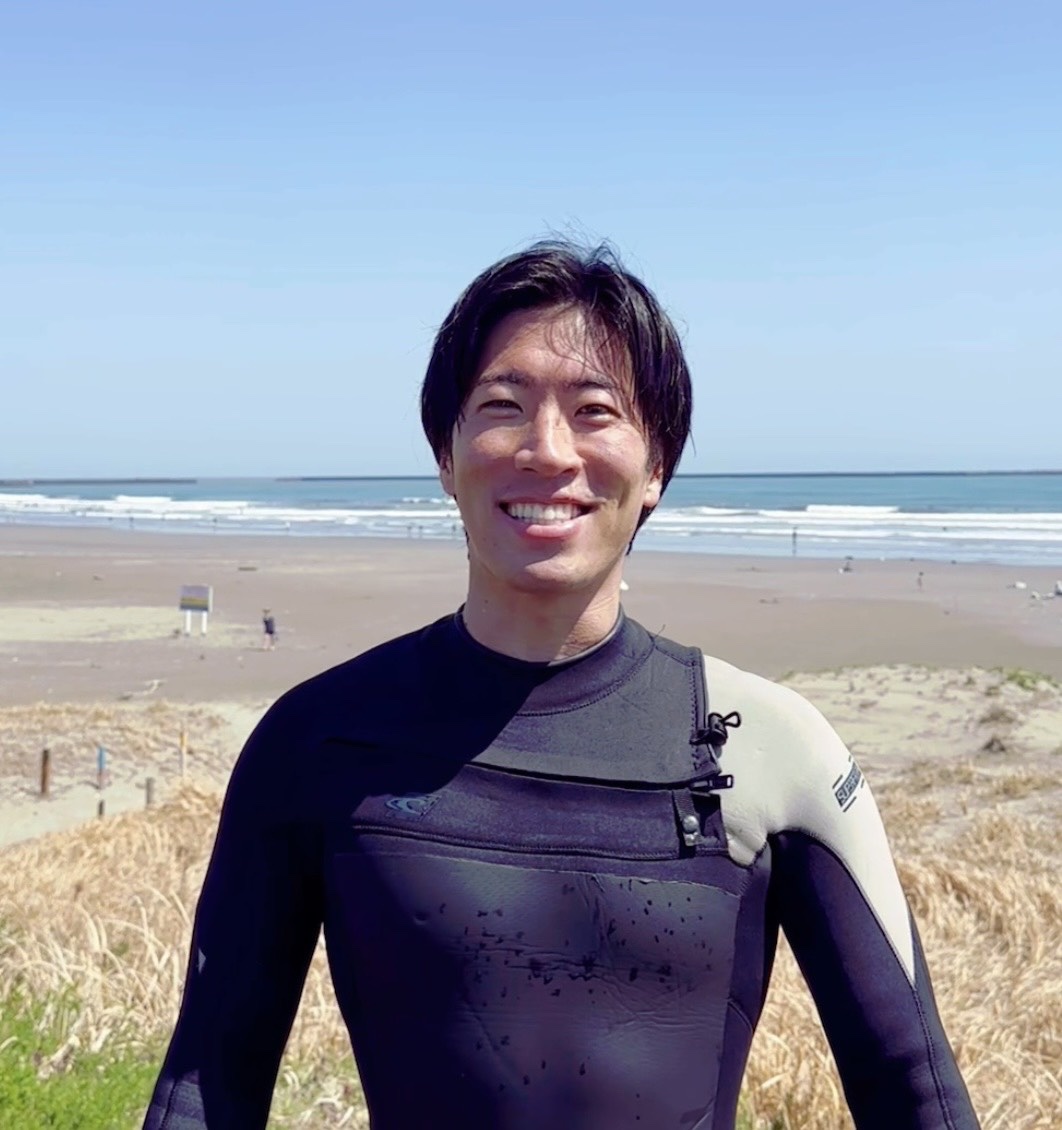 ウェットスーツ姿で浜辺に立つ乙部力斗